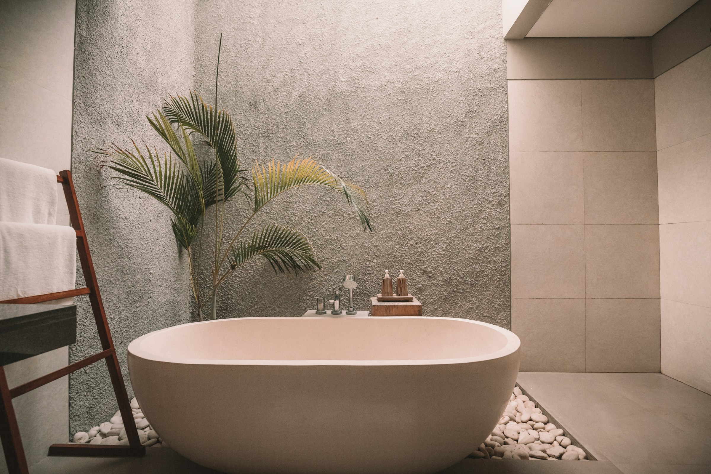 Calm bathroom remodel with a freestanding tub and textured stone surfaces